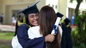 Proud and excited young woman hugging mom after the university...