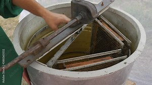 Manual centrifuge device that Spin the Honey from cells.Honey extractor is spinning with frames with honeycombs, honey pumping. Getting honey from honeycomb.