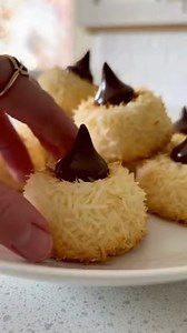 Coconut Macaroon Blossoms Golden Coconut Macaroon Blossoms with Chocolate Kiss Centers Recipe Ingredients: 3 cups sweetened shredded coconut 2/3 cup sweetened condensed milk 1 teaspoon vanilla extract 2 large egg whites 1/4 teaspoon salt 24 chocolate kiss candies, unwrapped Directions: Preheat oven to 325°F (165°C) and line a baking sheet with parchment paper. In a large bowl, combine shredded coconut, sweetened condensed milk, and vanilla extract until evenly mixed. In a separate bowl, beat the