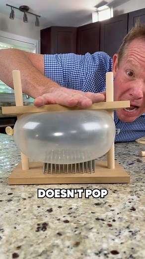 The balloon doesn't pop! FULL EXPERIMENT: https://stevespangler.com/experiments/bed-of-nails-tabletop/ #Science #Magic #SteveSpangler | Steve Spangler