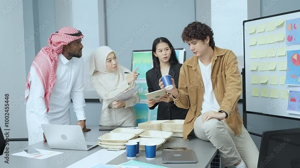 Multicultural business team brainstorming eco-friendly packaging ideas in a modern office, using whiteboards and presentation materials.