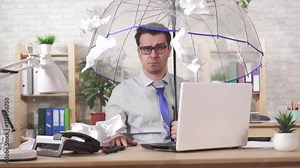 Concept excessive work,man office worker takes cover with an umbrella from a falling heaps of paper slow mo