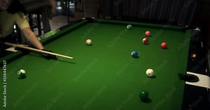 Billiard balls triangle starting position shot. Pool balls with numbers organized in form of pyramid on a green cloth table. white cue ball seen in a distance.Sports game of billiards on green cloth.