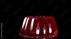 The red jelly rotates close-up on a black background, I hit it from above from the side, and it swings.Slow Motion