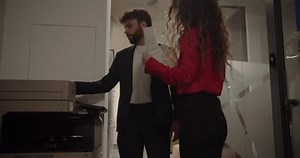 Two colleagues making photocopies in the office lobby, modern coworking space