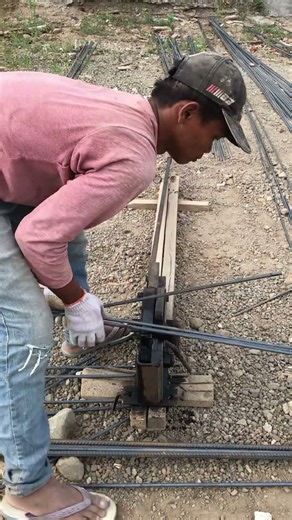a worker cuts the reinforcing steel for the footing foundation..