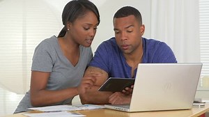 Couple noir utilisant une tablette pour consulter les comptes