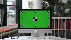Computer with green screen mockup display standing on work desk in a modern office. Computer with a blank green screen for your advertising or announcement