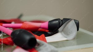 Rhythmic gymnastics equipment is on a white table. Gymnastic tape and mace are in the locker room