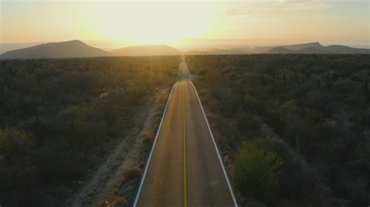 Symmetrical landscape around a road at sunset - Free Stock Video