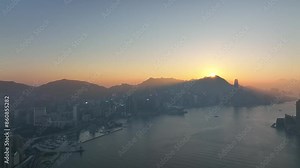 Aerial view of Hong Kong's stunning skyline and harbor, capturing the city's iconic skyscrapers, serene waters, and breathtaking sunset over Victoria Harbour