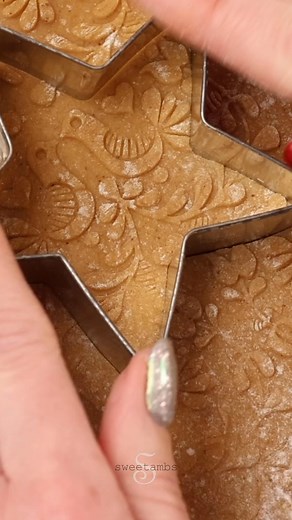 I used an engraved rolling pin to create these embossed gingerbread cookies. They're covered with a very thin layer of royal icing. #icingcookies #gingerbreadcookies #decoratedcookies #royalicingcookies #christmascookies #cookies #holidaybaking #embossedcookies | SweetAmbs