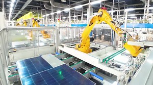 Premium stock video - Automated solar panels being moved by robot arms on conveyor belts during high tech production process in renewable energy factory, photovoltaic cells being placed on assembly lines