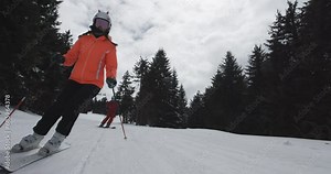 Woman and man skiers skiing on slopes. Couple having fun together. Ski run 4 clip 2of2. Recorded on cinema camera 50fps.