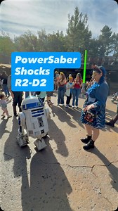 Nadia stopped by to show R2-D2 her new tech, and I think we have a fan! 🤖 As soon as the blade auto-extended, R2 went into a spinning frenzy of happy beeps. Even an Astromech droid knows impressive technology when he sees it! ⚔️ It was the perfect moment with our favorite little droid on the streets of Batuu. 🌌 #GalaxysEdge #R2D2 #powersaber | Galaxy's Edge Explorers