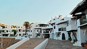Binibeca Coastal Village with whitewashed houses with wooden windows and doors. Binibeca Vell a Calm Cove Resort with narrow streets overlooking Mediterranean Sea in Menorca, Balearic Islands, Spain.