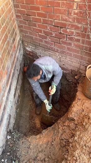 Construction Worker Digging Trench at Job Site