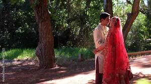 Happy Indian Couple Kissing On Their Wedding Day - Wide Shot