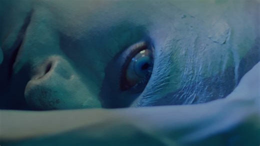 Close-up of the eye of a scared alien lying on the ground - Free Stock Video