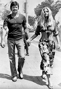 Charles Bronson and his wife Jill Ireland walking around town in style in 1971. While he looked like the picture of glamor, the actor had a dark childhood that many do not know about... 😭💔 More in the comments... 👇 | Scratcherchallenge