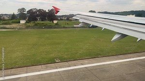 View from the window on the wing of an airplane landing on a warm summer day in slowmotion