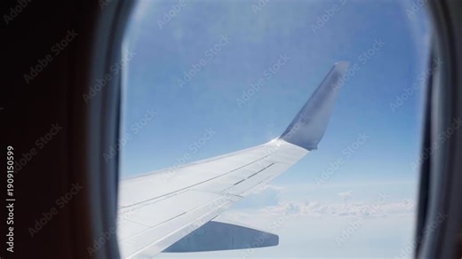 Closeup of window's seat view on a Airplane wing while flying, blue sky background