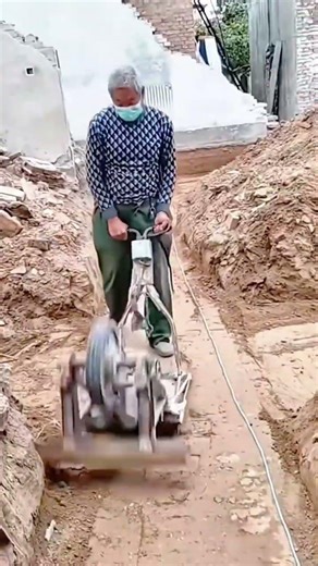 Construction Worker Operating a Vibratory Plate Compactor on Loose Soil Site