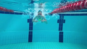 Une petite fille ou une adolescente nage sous l'eau dans la piscine. Tournage d'une vidéo sous l'eau pendant qu'un enfant nage dans un bassin