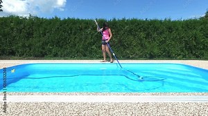 Cleaning the home pool. The woman sucks and cleans the swimming pool. Seasonal work from an aerial perspective.