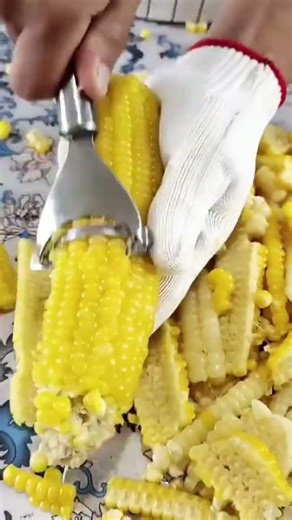This is the process of separating corn from its stalks using a tool. #shorts