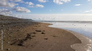 Footage of Fairbourne beach in Wales with pebbles covering the sandy beach.