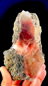Rarity Personified Stunning specimen of rare Moldy Raspberry Red Calcite with amazing color, clarity & size from Madhya Pradesh, India. The term “moldy raspberry” refers to the unique coloration and texture of these calcite specimens. While calcite is a known mineral, the specific combination of raspberry red coloration is very rare, making these specimens highly sought after by collectors. This rarity is reflected in the market, where such specimens are valued for their unique aesthetic and geo