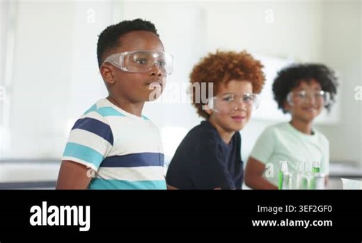 Three schoolboys in goggles at lab counter green rack appearing striped boy handling it learning. Students, science, classroom, bench, eyeprotection, experiment, teamwork Stock Video Footage - Alamy