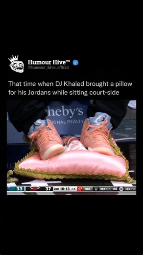 @humour_hive.io on Instagram: "In November 2022, American music producer and cultural figure DJ Khaled generated widespread attention—not for a music release, but for his behavior at an NBA game. While attending the Miami Heat vs. Charlotte Hornets matchup at the FTX Arena, Khaled was captured on video placing his feet—specifically his unreleased Air Jordan 5 “We The Best Crimson Bliss” sneakers—on a silk pillow rather than the floor. This incident sparked significant social media discussion and