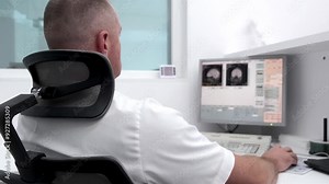 In a high-tech control room, a radiologist reviews brain scan results on monitors while a patient undergoes an MRI or CT scan. Ideal for showcasing advanced medical diagnostics and equipment.