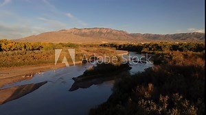 Rio Grande Bosque in the Fall - Aerial over Rio Grande River with Sandia Mountains in the background, edge of Albuquerque showing next to Sandia Pueblo Lands