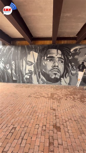 🌃 🎨 New J. Cole Mural Taking Shape In Downtown Fayetteville 🏙️ A new J. Cole mural is currently being painted under the Maiden Lane Bridge in downtown Fayetteville, located between the Fayetteville Library and Dogwood & Festival Park 🖌️ The mural is being created by Malkolm Herring, known for detailed, expressive public artwork that captures emotion and place 👷🏾‍♂️ The piece is still in progress, and these images show what it looked like when FayToday stopped by on 2-6 Day 🎶 A strong visu