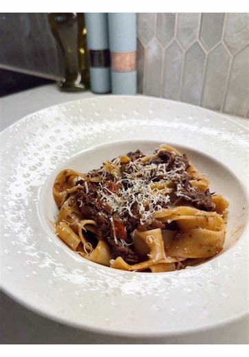 Amazing homemade pappardelle pasta with slow braised beef ragu and shredded cheese
