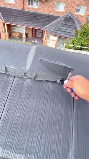 applying mortar to seal the ridge cap tiles on the roof