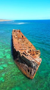 Hawai‘i’s Ghost Ship Somewhere along Hawai‘i’s coastline lies the haunting remains of an old World War II–era ship. Built from concrete in the 1940s, it once carried fuel for the U.S. Navy before being abandoned to the sea.Now, its rusting frame rises out of the water, a playground for fish and seabirds and a striking reminder of how history and nature intertwine. What was once a wartime vessel has become one of Hawai‘i’s most unforgettable coastal sights. Do you know where this mysterious shipw
