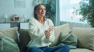 Portrait of young woman relaxing, dancing at home and listening music. Girl sitting on sofa. Relaxation, Meditation and Mindfulness. 4K