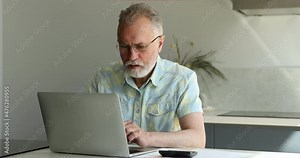 Serious older age male retiree make home accounting work sit by pc provide utility bills payment review family finances count expenses on calculator. Focused man pensioner think on financial documents