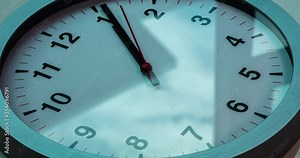 Wall clock show the running time. Time lapse on a modern wall clock. Close up to a wall clock, with running time pointer. Sun and sky reflecting in the watch during the time passing by