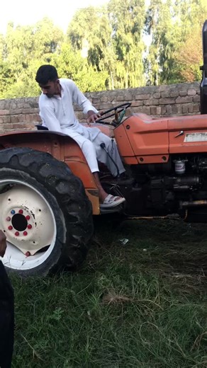 Operating an Orange Tractor in a Grassy Area