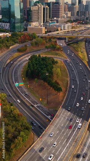 Wide multi-lane highway crossing Atlanta city landscape with recognizable skyscraper buildings, continuous traffic flow and contemporary urban architecture in the USA.