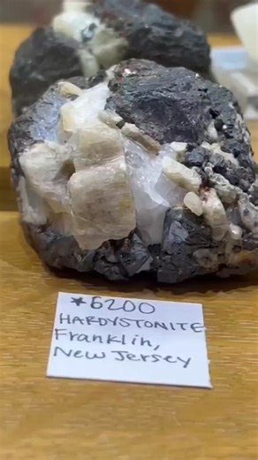 💎 Hardystonite (Ca₂Zn[Si₂O₇]) – a calcium zinc sorosilicate mineral of the melilite group, crystallising in the tetragonal system. Typically light brownish white to pale grey or pinkish in colour, with an adamantine to resinous or dull lustre. It has a hardness of 3–4 and a specific gravity between 3.396 and 3.443. Hardystonite occurs as massive material with a somewhat greasy appearance, lacking cleavage, and is generally distinguished from similar minerals by physical properties rather than a