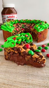 Nutella Stuffed Christmas Cookie Pie 😍 Grab you're Red and Green M and M's and share this one at a party or with family! It's my Christmas Cookie Pie Soft chocolate chip and M&M cookie dough, stuffed with a thick, gooey layer of Nutella, topped with a creamy buttercream icing and festive sprinkles 🤤 This cookie pie is so chocolatey and indulgent and perfect for the festive season🎄 Sound on for full instructions 🔉 All you need is: For the cookie dough: 200g unsalted butter, softened 250g ligh
