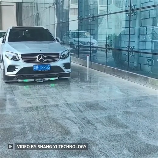 Shang Yi Technology is testing an autonomous vehicle transportation system in Shenzhen. A tatami-like robot moves cars by crawling underneath and maneuvering them without needing to start the engine. It can navigate tight spaces using precise mapping and works indoors without emitting exhaust. Demonstrations in Yokohama also showcase remote control and multi-unit automation. It supports vehicles up to 3 tons and functions in light rain with puddles up to 2cm deep. Video Credit: Shang Yi Technolo
