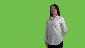 Woman with wireless lav mic attached to shirt during presentation showing something behind her doing OK gesture against a green screen. 4k footage PNG with alpha channel