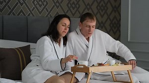 Young Man and Woman Having Breakfast in Bed